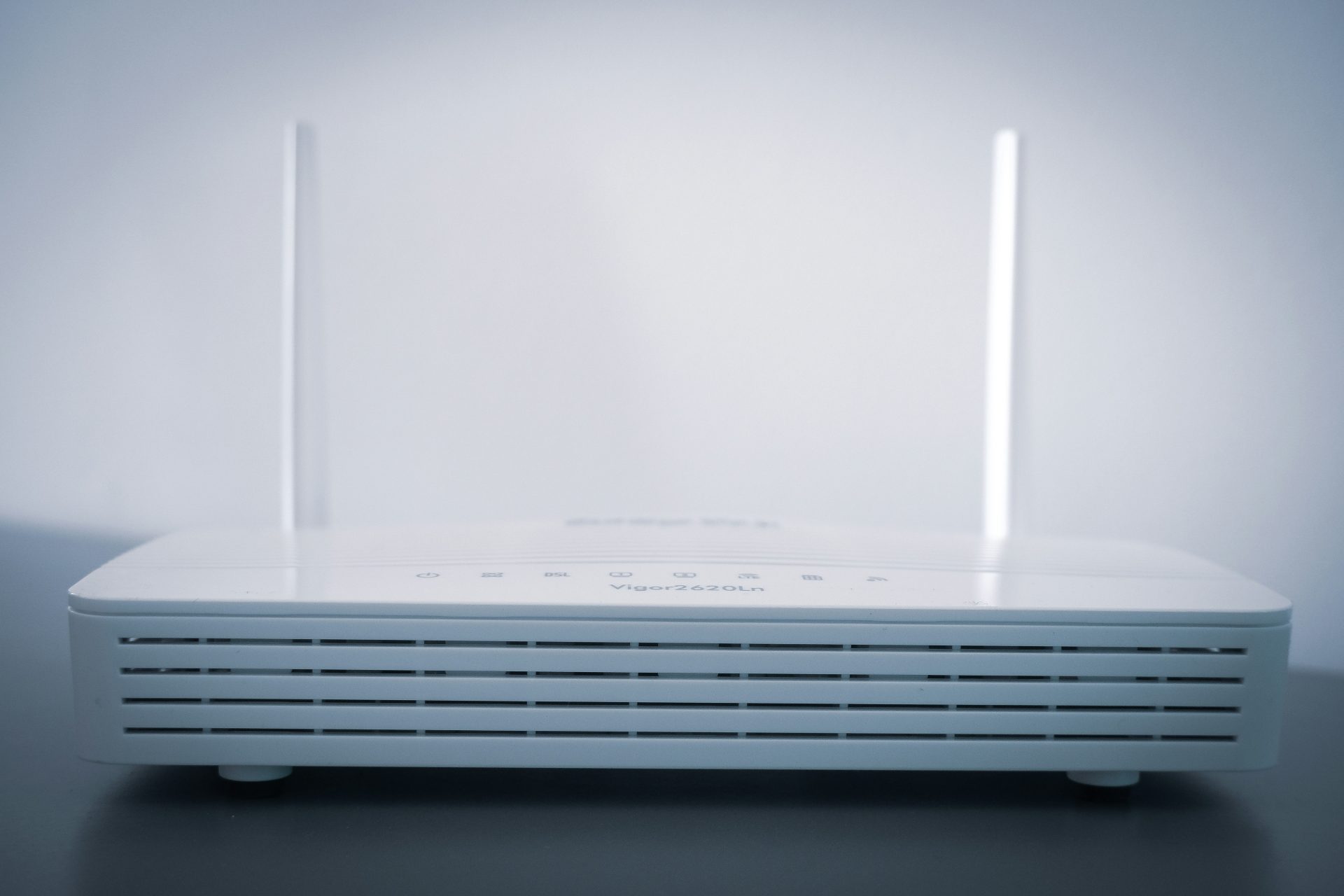 The Best in 2025 Ubiquiti UniFi Dream Machine Pro UDM-Pro 4 A white DrayTek Vigor2620Ln router with two antennas is centered against a soft, bright background.