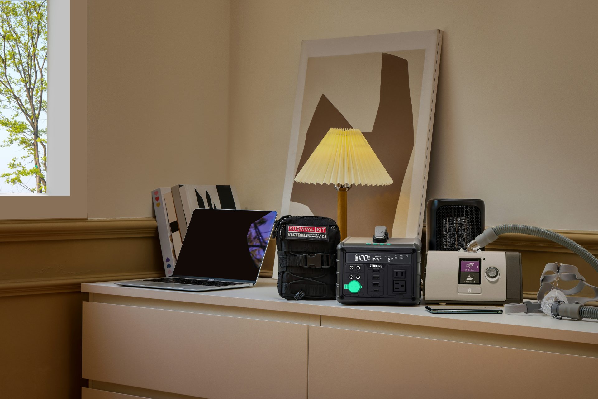 The Convenience of Wireless Multiroom Audio in Your Home in 2025 3 A laptop, survival kit bag, portable power station, small heater, and CPAP machine are neatly arranged on a light-colored dresser in a room with a window and framed artwork on a wireless multiroom.
